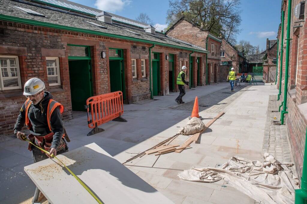 A man walking across the shippon yard