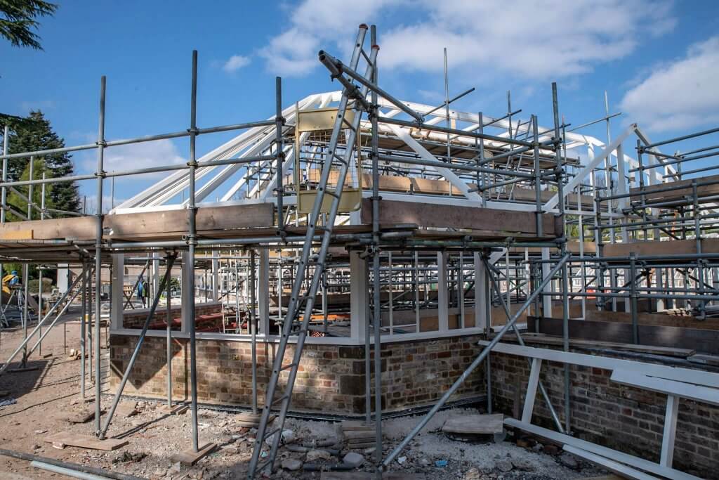 Scaffold erected around the timber glasshouse frame