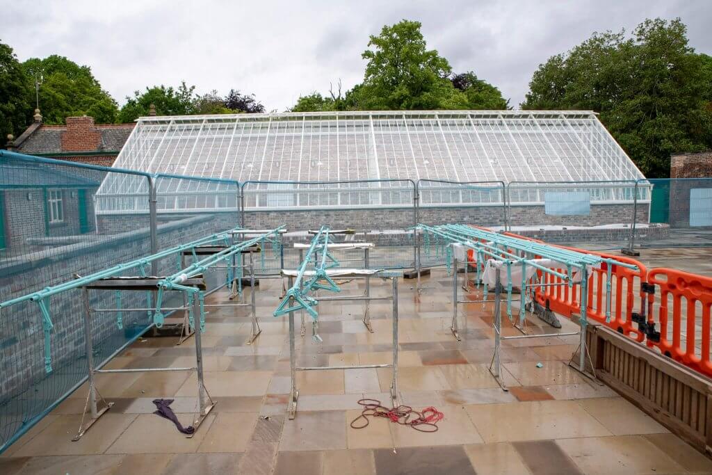 The ironwork being repainted during restoration of the conservatories