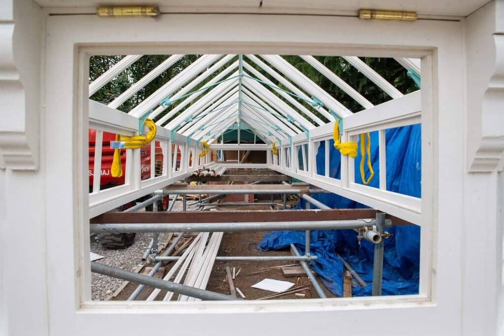 A picture looking through the timber frames of the glasshouses.