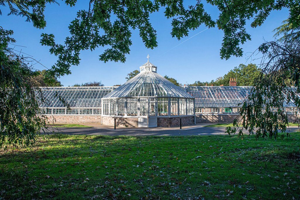 The glasshouses seen from across the lawns at Walton Hall and Gardens