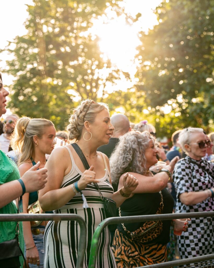 close up of the front row of the crowd, all looking up to the stage and dancing.