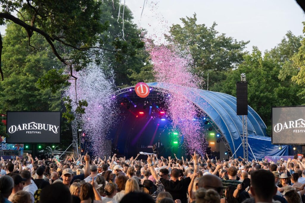 confetti cannons explode from the stage into a cheering crowd.